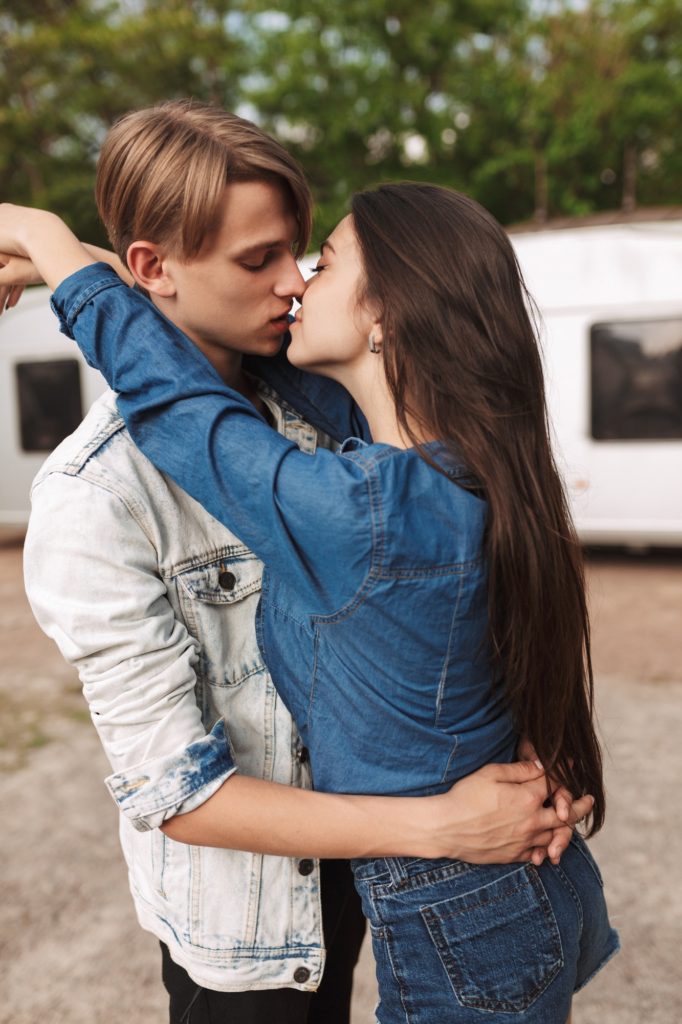 Romantic beautiful couple embracing and kissing each other in park. Young couple on a date